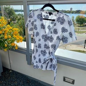 White wrap top with dark blue floral pattern